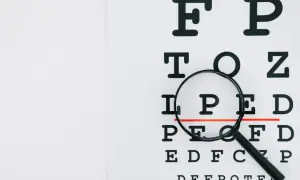 Lupa powiększająca litery na tablicy optometrycznej.