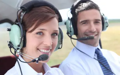 Para, czy pilot może mieć wadę wzroku? Dwoje ludzi w słuchawkach z mikrofonem w samolocie.