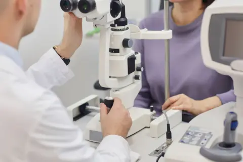Okulista bada pacjentkę, która może mieć neuropatię nerwu wzrokowego.