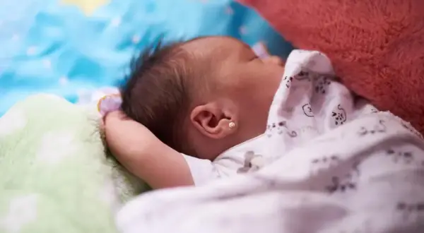 Śpiące dziecko, jak widzi 3 miesięczne dziecko: rozmyte kształty, jasne kolory, miękkie koce i pluszaki.