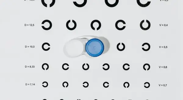 Tabela optometryczna z pierścieniami Landolta i pojemnikiem na soczewki kontaktowe.