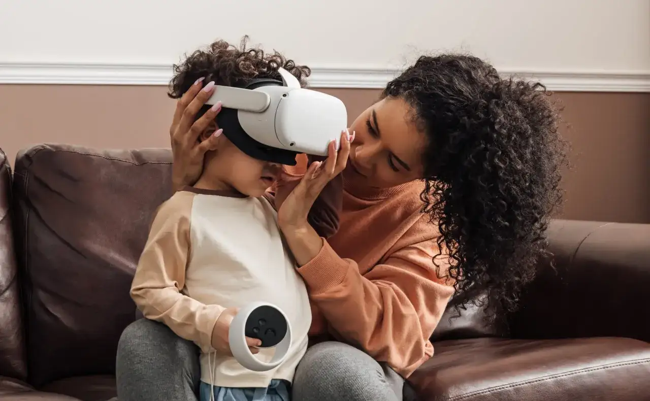 Dziecko w goglach VR z rodzicem, ujęcie pokazujące ostrożność